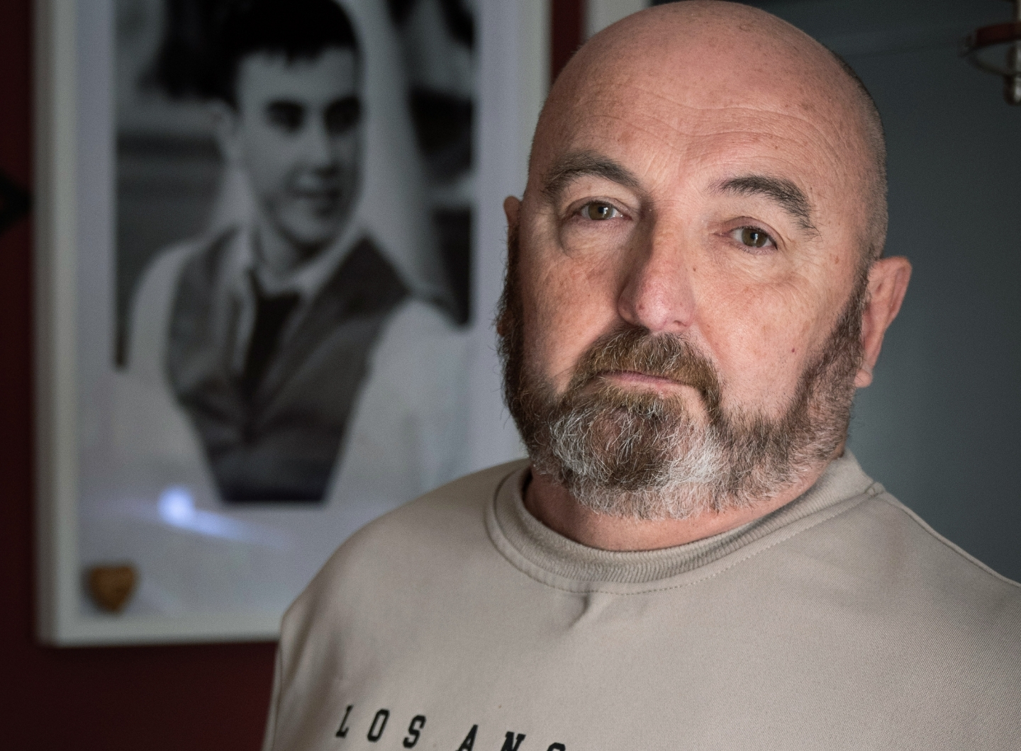 Phil Wanless in front of a photo of his son Fraser